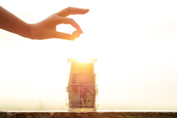 concept of accumulating money in a glass jar in the sunlight with the help of the sun