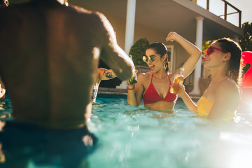 Happy friends making party inside pool