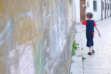 Obraz na płótnie Canvas A boy of school age dressed in stylish clothes on a city street