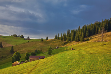 hay stack on the grassy meadow in mountain. beautiful countryside landscape under the blue sky