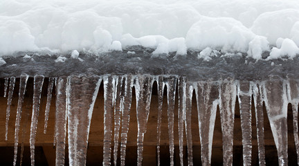 Snow covered roof with icicles. Bad weather, winter season concept, soft focus, shallow depth field.