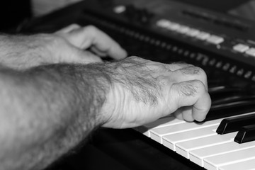 Male hands of a musician who plays music on a synthesizer
