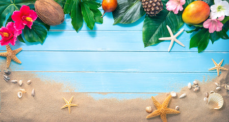 Holidays background with tropical flowers, leaves, exotic fruits and seashells on sand beach