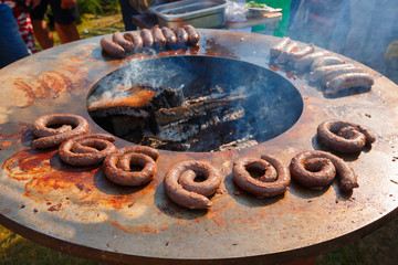 Different sausages fried in barbecue on outdoors