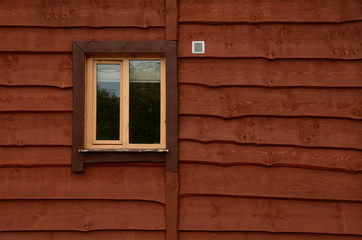 The wall of a wooden farmhouse with a window. Background. Texture.