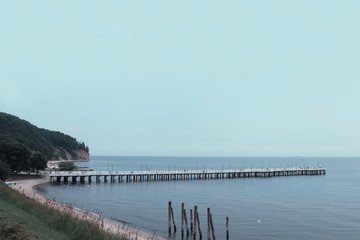 Obraz premium Pier on the beach, with a clear sky and calm sea with sandy beach. Photo of an amazing nature