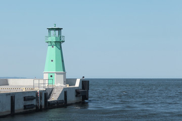 Fototapeta premium Lighthouse on with a clear sky and calm sea. Photo of an amazing nature