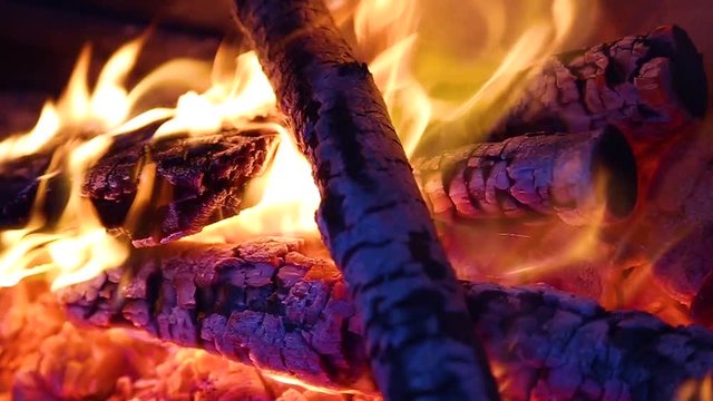 Closeup view of burning firewood with bright fire inside of fireplace. Slow motion hd video footage.