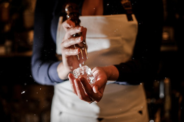 Professional female bartender breaking an ice cube