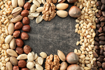 Frame made of different nuts on grey background