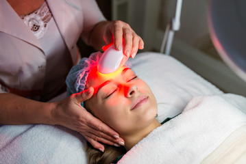 Skin Care. Young Woman Receiving Facial Beauty Treatment, Removing Pigmentation At Cosmetic Clinic....