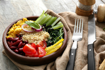 Plate with tasty quinoa salad on wooden table