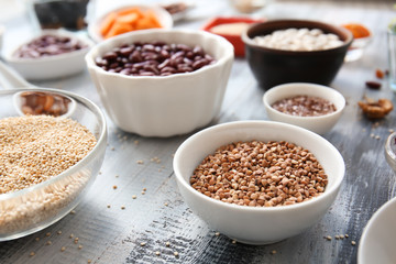 Bowls with various healthy products on wooden table