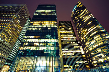 Illuminated office buildings in Paris business district La Defense. Night city lights, skyscrapers...