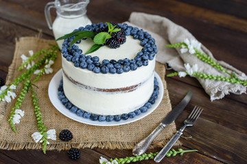 Beautiful tasty cake with white cream and berries of blueberry