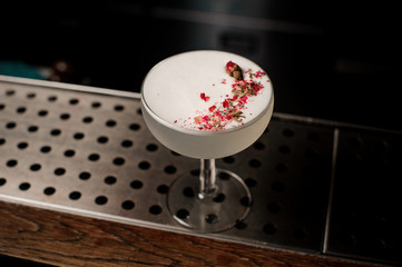 Delicious white cocktail decorated with dried flowers