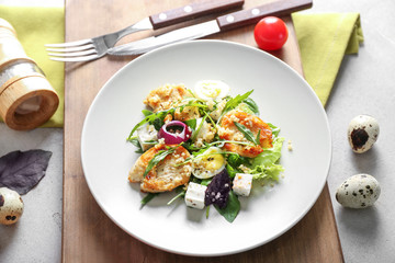 Plate with tasty chicken salad on wooden board