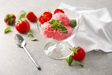 Dessert bowl with delicious strawberry ice-cream on grey background