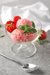 Dessert bowl with delicious strawberry ice-cream on grey background