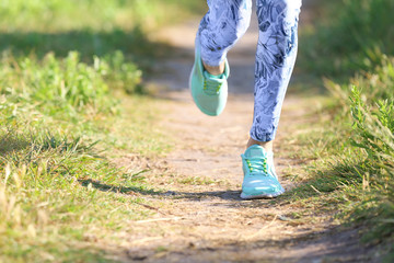 Beautiful young woman running in park