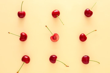 Flat lay composition with ripe cherries on color background