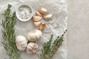 Fototapeta na wymiar Fresh herbs with garlic and salt on grey textured background