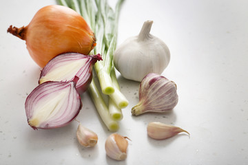 Different fresh onion with garlic on light background