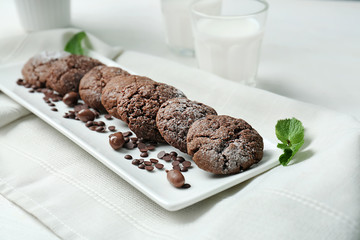Plate with delicious chocolate cookies and candies on table