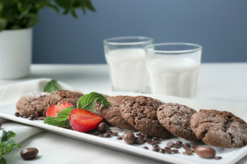 Plate with delicious chocolate cookies and fresh strawberry on table