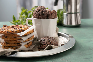 Tray and cup with tasty chocolate cookies on table