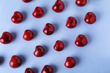 Flat lay composition with ripe cherries on color background