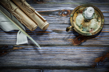 Vintage paper rolls quill candlestick candle on blue wooden boar