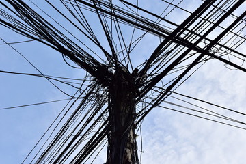 Large steel eletric support with a lot of tangled wires, cables. Complete confusion and mess