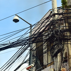 Electric support with a lot of tangled wires, cables and a 360 degree surveillance camera (circular)