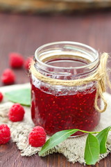 Raspberry jam in a jur and fresh berries on the table