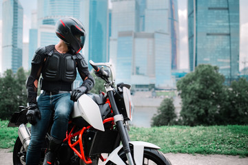 Fototapeta na wymiar Biker and motorcycle near downtown city urban district