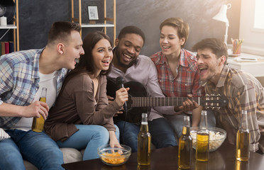 Friends enjoying singing and playing guitar