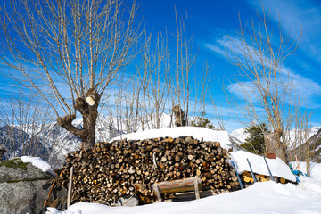 firewood stacked under snow in Pyrenees Spain