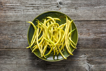 Fresh bean, organic vegetables on plate prepared to cooking, freshly harvested yellow beans on table