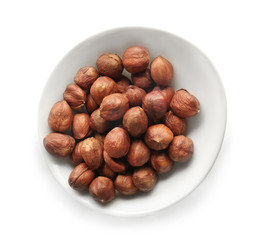 Bowl with tasty hazelnuts on white background