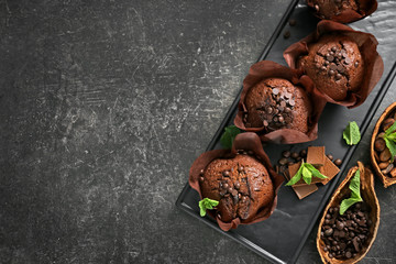 Plate with tasty chocolate muffins on grey table