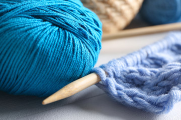 Ball of knitting yarn with needle on table, closeup