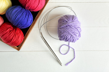 Balls of knitting yarn with needles on light background