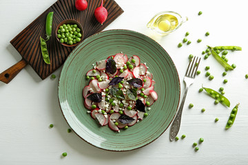 Composition with green peas salad on light table
