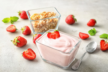 Bowl with tasty strawberry yogurt on light table