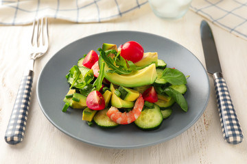 Plate with tasty avocado salad on table
