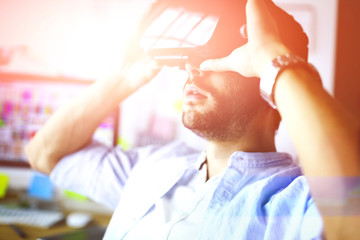 Young male software programmer testing a new app with 3d virtual reality glasses in office
