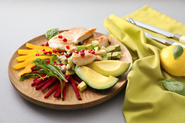 Plate with tasty avocado salad on table