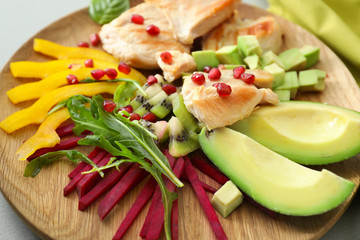 Ripe avocado, vegetables, herbs and meat on plate, closeup