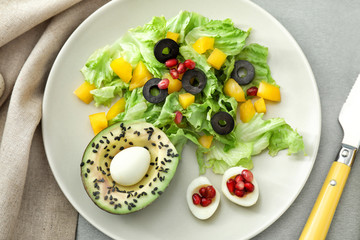 Plate with tasty avocado salad on table